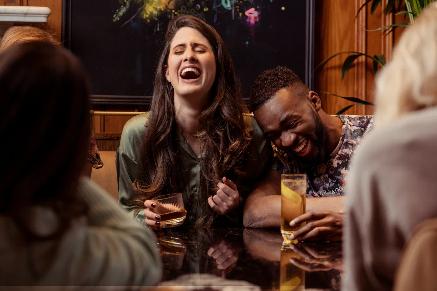 A group of people sitting around a table, laughing